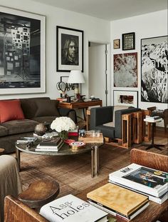 a living room filled with lots of furniture and pictures on the wall above it's coffee table