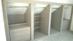 an empty white closet with drawers and shelves