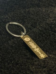 a metal keychain with the words happy birthday on it sitting on a black surface