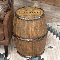 a wooden barrel sitting on top of a rug next to a brown chair and ottoman