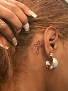 a woman with a cross tattoo on her ear