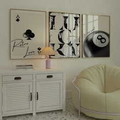 two paintings hang on the wall next to a white cabinet with drawers and a lamp