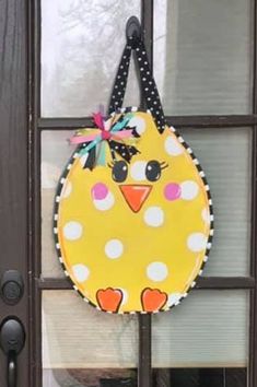 a door hanger with a yellow bird on it's face and polka dots