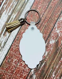 a white keychain with a tassel hanging from it