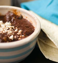 a bowl filled with food next to tortilla chips