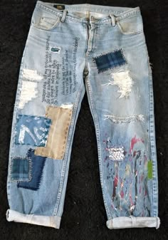 an old pair of jeans with patches and paint on them