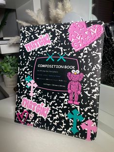 the composition book is decorated with pink and black designs