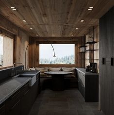 a kitchen with wooden walls and flooring next to a window that looks out onto the mountains