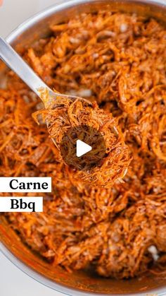 a spoon full of shredded carrots in a pot with the words carne bbq on it