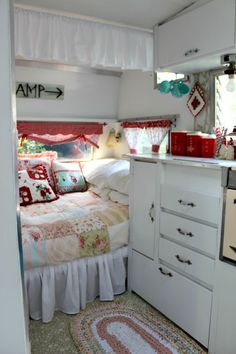 a small bedroom with a bed, dresser and rug in the corner next to an oven