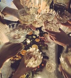 several people toasting with wine glasses on a table