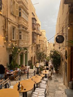 an alleyway with tables and chairs lined up