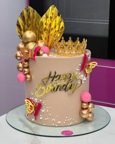 a birthday cake decorated with gold and pink decorations