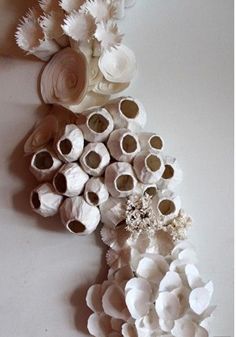 there are many flowers made out of toilet paper rolls on the wall in this room