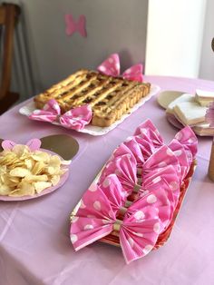 a table topped with lots of food on top of a purple table cloth covered table