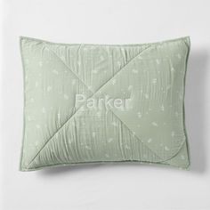 a green pillow with the word parker printed on it