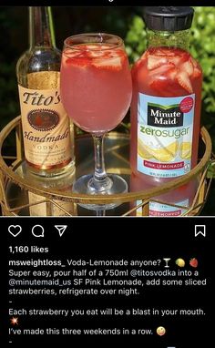 two bottles of alcohol sitting on top of a table next to a glass filled with liquid