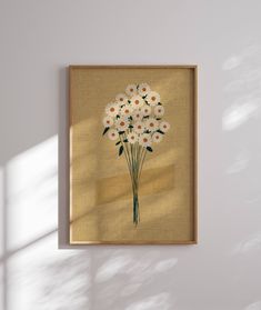 a painting hanging on the wall next to a vase filled with white and orange flowers