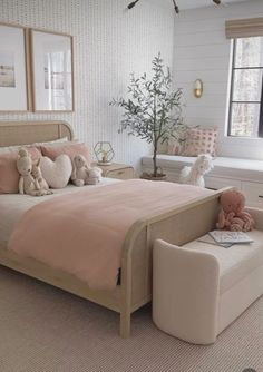 a bed room with a neatly made bed and two teddy bears on the foot board