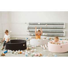 two children playing in an indoor ball pit