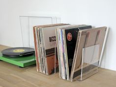 three records are stacked next to each other on a table with a record player in the background