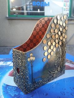 a sculpture made out of metal and gold coins on a blue table in front of a store