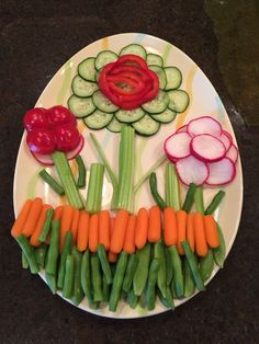 a plate with carrots, celery, and cucumbers on it