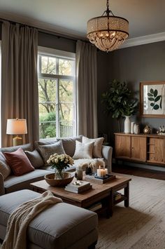 a living room filled with furniture and a chandelier hanging from the ceiling next to a window