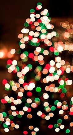 a blurry christmas tree with lights in the background