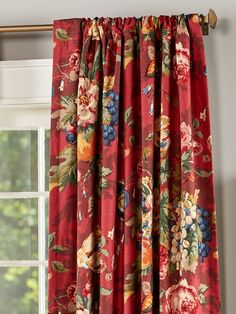 a red floral curtain hanging in front of a window