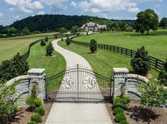 a gated driveway leading to a large house