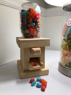 two jars filled with candy sitting next to each other on top of a white table