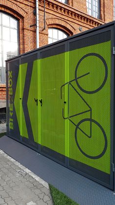 a large green screen on the side of a building with a bicycle graphic on it