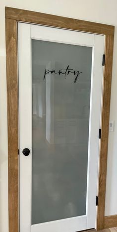 a glass door with the word pantry written on it in cursive writing next to a wooden frame