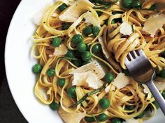 a white bowl filled with pasta and peas