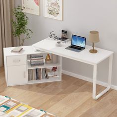 a computer desk with a laptop on top of it next to a lamp and bookshelf