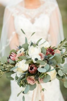 a bridal holding a bouquet of flowers and greenery