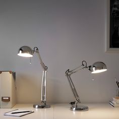 two desk lamps sitting on top of a white table