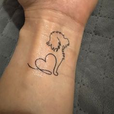 a small tattoo on the wrist of a woman with a dog and heart in it