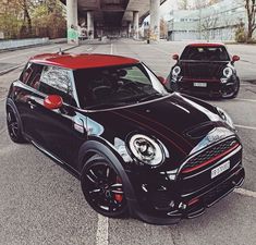 two cars parked next to each other in a parking lot near an over pass bridge