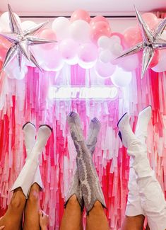 two women's legs with white boots and pink streamers hanging from the ceiling