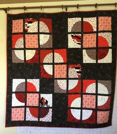 a black and red quilt hanging on the wall