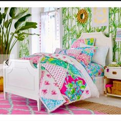 a white bed sitting in a bedroom next to a green plant on top of a pink rug