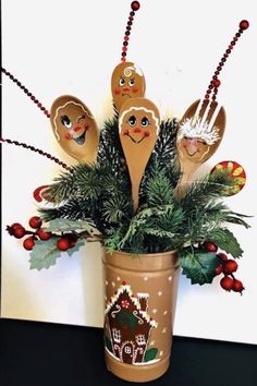 some wooden spoons are sitting in a pot with christmas decorations on top of it