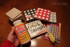 a person is holding some craft supplies on a table