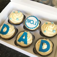 six cupcakes in a box with blue and white frosting