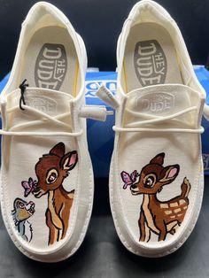 a pair of white shoes with deer on them