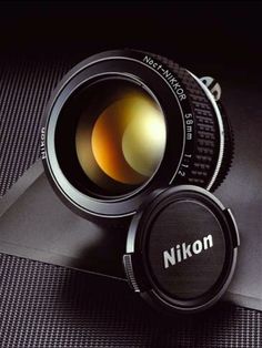 a camera lens sitting on top of a piece of black paper with the word nikn written