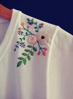 an embroidered white shirt with flowers on it