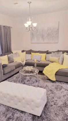 a living room filled with furniture and a chandelier hanging above the couches